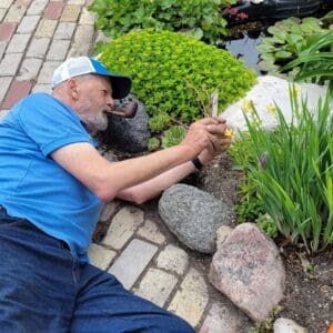 Gardener inspecting plants by the pond