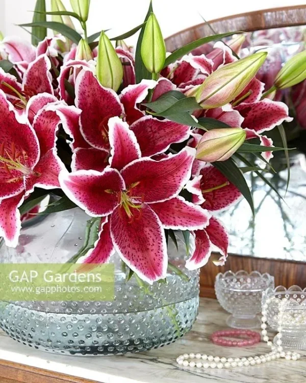 Pink lilies in a glass vase arrangement.