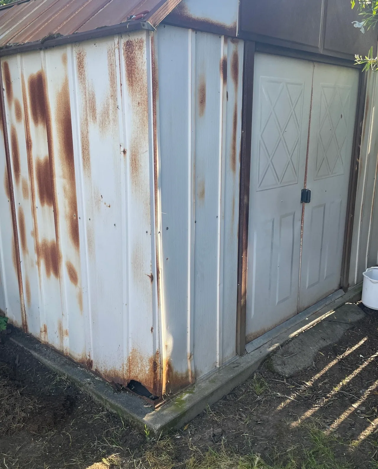 Rusty metal shed with double doors.