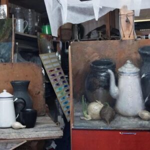 Two vintage shelves displaying old kitchenware and stuffed animals.