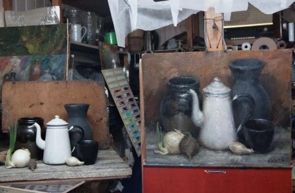 Two vintage shelves displaying old kitchenware and stuffed animals.