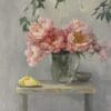 Soft pink flowers in a glass jug on a rustic table with lemon slices.