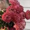 A bouquet of vibrant pink roses held by a person.