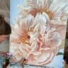 Artist painting a large, detailed pink flower on canvas.