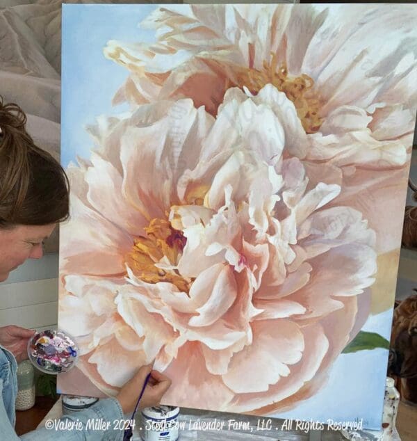 Artist painting a large, detailed pink flower on canvas.