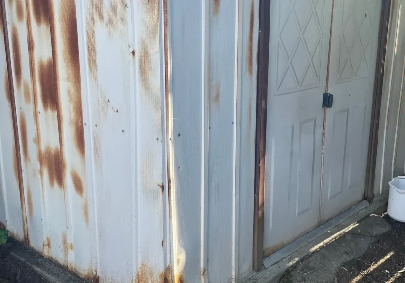 Rusty metal shed with double doors.